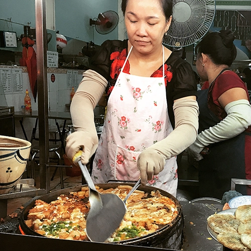 Nằm ngay mặt đường Võ Văn Tần, quận 3, quán bột chiên này mở bán cách đây 30 năm. Theo lời chủ quán, ngày trước nơi này ít người biết đến. "Người này đến ăn rồi truyền tai cho người khác nên quán mới đông như bây giờ", chủ quán vừa chiên bánh vừa nói. Nằm ngay mặt đường Võ Văn Tần, quận 3, quán bột chiên này mở bán cách đây 30 năm. Theo lời chủ quán, ngày trước nơi này ít người biết đến. "Người này đến ăn rồi truyền tai cho người khác nên quán mới đông như bây giờ", chủ quán vừa chiên bánh vừa nói.