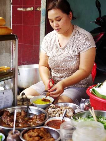 Quán nhỏ nằm cạnh chợ Xóm Mới tiện cho cả người bán hàng nghỉ trưa ăn và khách đi mua hàng ghé vào. Ảnh: Hương Chi.