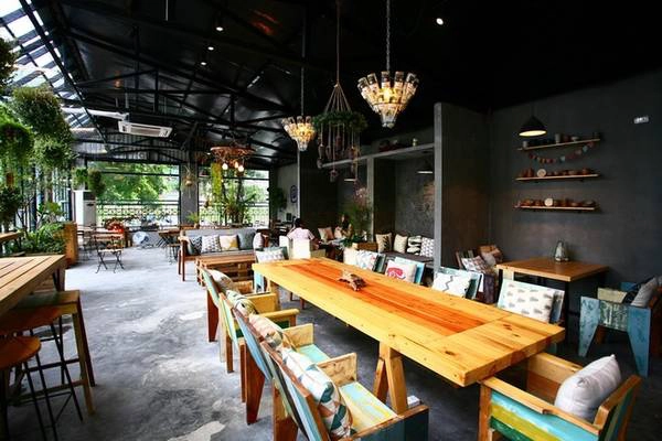 Bàn ghế bài trí khá đa dạng với nhiều chỗ ngồi. Có những bàn lớn dành cho nhóm đông người và có cả những góc nhỏ 2 người hay khách một mình. Màu của trần đen và màu tường ghi sẫm, sàn xi măng xám tạo nên chiều sâu cho không gian và cân bằng với ánh sáng từ bên ngoài. Đồ nội thất theo phong cách mộc, giản dị nhưng bắt mắt. Bàn ghế bài trí khá đa dạng với nhiều chỗ ngồi. Có những bàn lớn dành cho nhóm đông người và có cả những góc nhỏ 2 người hay khách một mình. Màu của trần đen và màu tường ghi sẫm, sàn xi măng xám tạo nên chiều sâu cho không gian và cân bằng với ánh sáng từ bên ngoài. Đồ nội thất theo phong cách mộc, giản dị nhưng bắt mắt.