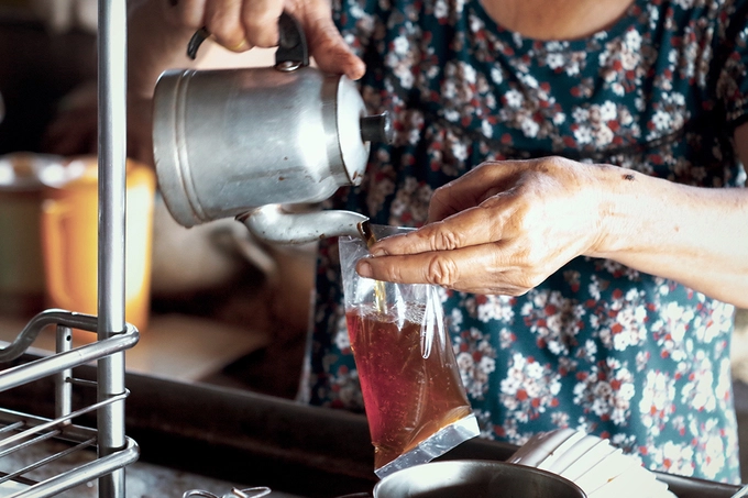 Khi có người mua mang về, đúng kiểu cà phê bình dân, bà Hạnh chế cà phê vào một bịch bóng cột chặt lại, thêm một túi trà to gấp đôi rồi bỏ túi nilon cho khách. Khi có người mua mang về, đúng kiểu cà phê bình dân, bà Hạnh chế cà phê vào một bịch bóng cột chặt lại, thêm một túi trà to gấp đôi rồi bỏ túi nilon cho khách.
