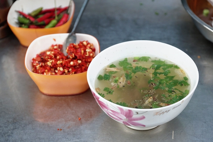 Chén nước súp được phục vụ kèm là nước luộc gà thơm lừng, có thêm chút hành phi và hành lá xắt nhuyễn, tỏa mùi hấp dẫn. Nhờ vậy, khách nào ăn chua không quen có thể húp một muỗng để vị chua trong miệng nhạt lại.