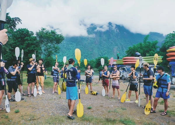 Hướng dẫn viên hướng dẫn một nhóm khách chuẩn bị hành trình trèo thuyền kayak 7km trên sông Nam Song. Ảnh: Mai Hương