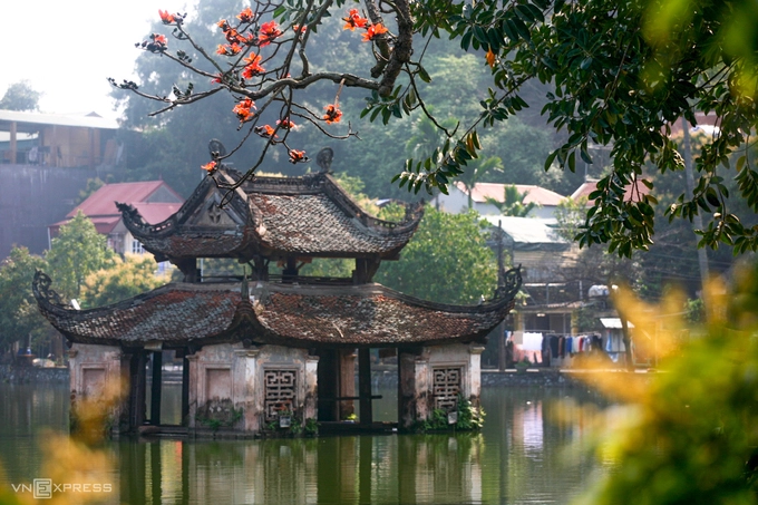 Nhành hoa gạo sà xuống trước thủy đình trên hồ. Đây là kiến trúc biểu tượng của chùa Thầy. Thủy Đình cổ kính, rêu phong, được ví là viên ngọc giữa miệng rồng. Vào những ngày lễ hội, nơi này trở thành sân khấu của các nghệ sĩ múa rối nước.