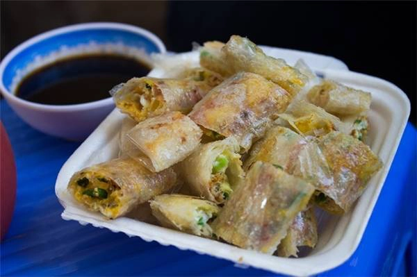 Bánh tráng mỏng, phết lên một chút pa tê thơm thơm, bơ béo ngậy, hành, trứng, sau đó khéo léo cuộn lại và chiên lên. Bánh tráng chiên ra lò, ăn với nước chấm chua chua để làm dịu bớt vị mặn, và rồi biết bao người nhớ hoài vào mỗi buổi chiều “bỗng dưng đói bụng”. (Ảnh: Internet) Bánh tráng mỏng, phết lên một chút pa tê thơm thơm, bơ béo ngậy, hành, trứng, sau đó khéo léo cuộn lại và chiên lên. Bánh tráng chiên ra lò, ăn với nước chấm chua chua để làm dịu bớt vị mặn, và rồi biết bao người nhớ hoài vào mỗi buổi chiều “bỗng dưng đói bụng”. (Ảnh: Internet)