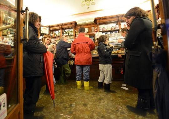 Người dân và du khách đứng uống cà phê trong một cửa hàng ở Venice, 11/11/2012.