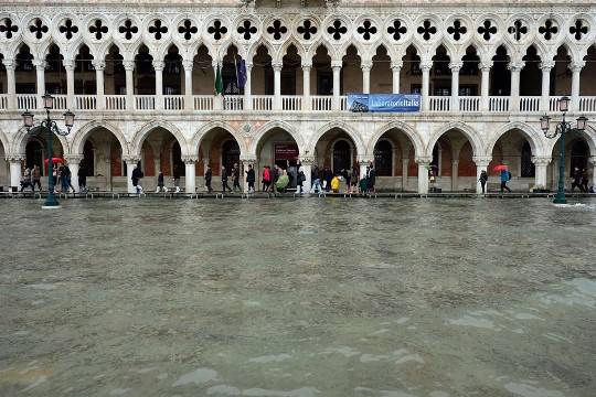 Dòng người bước đi trên một chiếc cầu gỗ trước cung điện Doges khi Venice bị ngập nước, 01/11/2012.