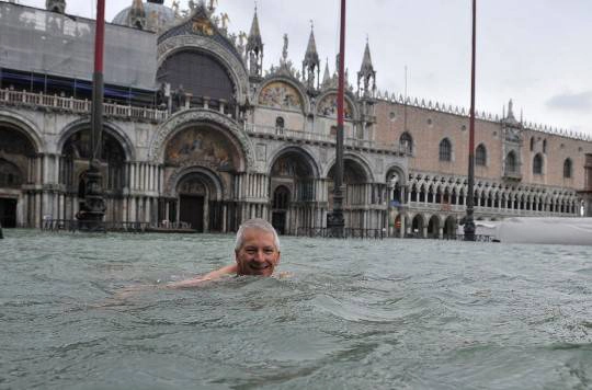 Một người đàn ông bơi trong dòng nước trước quảng trường Thánh Mark, Venice, 11/11/2012