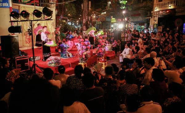 Hơn 22h, góc phố Mã Mây - Lương Ngọc Quyến thuộc khu phố đi bộ chật cứng người. Mặc dù trời lạnh, không gian vẫn được sưởi ấm bằng những điệu hát văn. Nhóm nghệ sĩ của Trung tâm Phát triển Nghệ thuật Âm nhạc Việt Nam đang biểu diễn văn bài "cô Bơ".