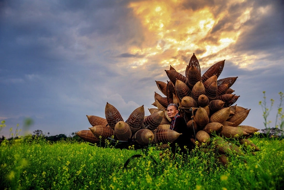 Cụ ông Lương Sơn Bạc đã hơn tuổi bát tuần vẫn yêu đời, yêu nghề đan đó - Ảnh: NGUYỄN TẤN TUẤN