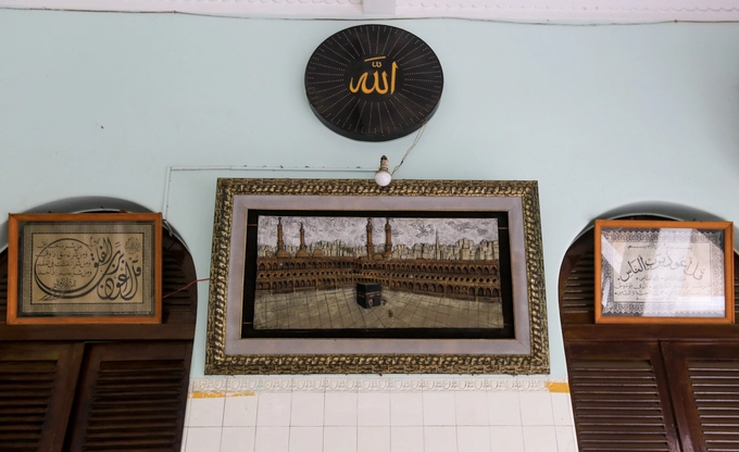 Bức tranh thánh địa Mecca ở Saudi Arabia, thủ đô tinh thần của thế giới Hồi giáo, được treo trang trọng trong một góc hành lang. Bức tranh thánh địa Mecca ở Saudi Arabia, thủ đô tinh thần của thế giới Hồi giáo, được treo trang trọng trong một góc hành lang.
