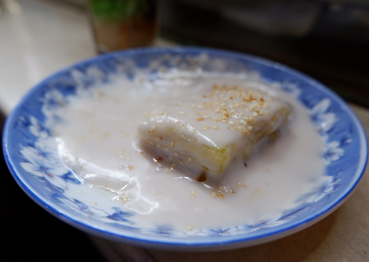 Phần bánh chuối chan thêm nước cốt dừa thơm béo, rắc ít mè rang bùi bùi nữa là đúng chuẩn. Giá một phần 27.000 đồng. Phần bánh chuối chan thêm nước cốt dừa thơm béo, rắc ít mè rang bùi bùi nữa là đúng chuẩn. Giá một phần 27.000 đồng.