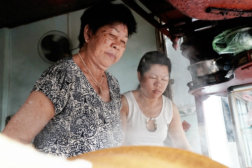 Vợ ông Há (trái) cùng con gái đang chuẩn bị món ăn cho khách. Ảnh: Di Vỹ. Vợ ông Há (trái) cùng con gái đang chuẩn bị món ăn cho khách. Ảnh: Di Vỹ.