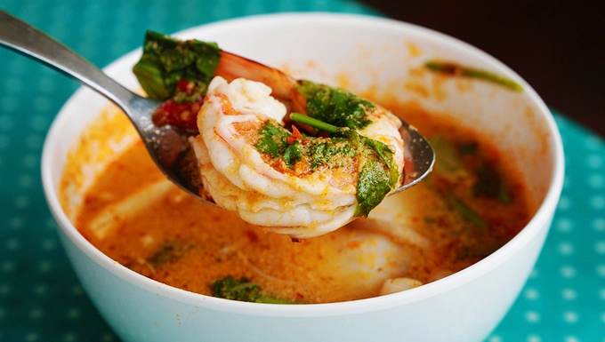 Tom Yum (canh truyền thống)  Đây là món súp cay, rất nổi tiếng ở Thái Lan. Món ăn là sự kết hợp của những loại hải hải tươi ngon, các loại gia vị tạo ra vị chua và cay nồng. Bạn còn cảm nhận được vị béo ngậy từ nước cốt dừa cùng các loại rau thơm. Nguyên liệu chính của món ăn được làm từ tôm hoặc thịt gà, nấm, lá chanh Thái, riềng, sả, nước dừa... Tùy từng nơi nguyên liệu của món này có thể thay đổi với các loại hải sản khác nhau. Món ăn dễ dàng tìm thấy tại các quán đường phố hoặc nhà hàng, giá dao động từ 100 baht (hơn 70.000 đồng). Ảnh: Phong Vinh.