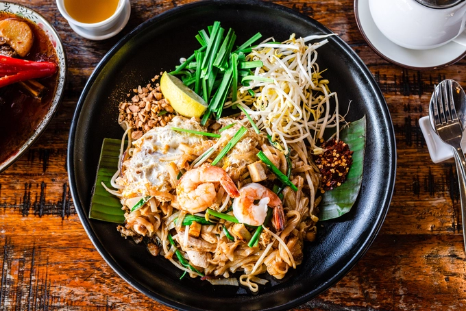 Pad Thai (phở xào)  Pad Thai từ lâu là "món ăn quốc gia" của Thái Lan, ra đời trong thời điểm đất nước này gặp khó khăn, khi người dân phải trộn tất cả nguyên liệu có sẵn vào làm một món. Về cơ bản, Pad Thai gồm có mì, trứng, tôm, giá và các loại rau củ quả khác. Các quán Pad Thai nổi tiếng thường thu hút khách hàng với công thức đặc biệt. Giá món này khoảng 80 baht (gần 50.000 đồng) cho một phần Pad Thai cơ bản loại nhỏ. Ảnh: Shutterstock/Giulia M.