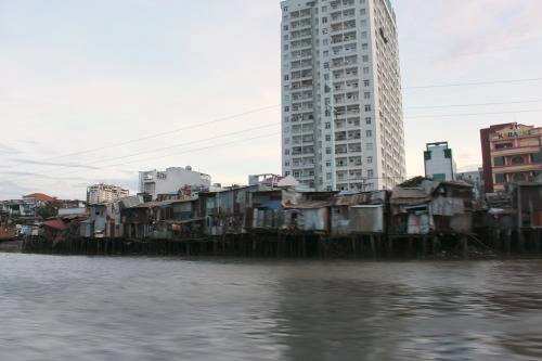 Những căn nhà mái tôn đỏ dọc bờ sông là một phần đặc trưng của thành phố. 