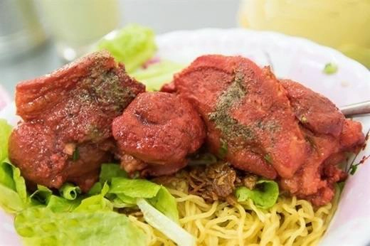 Màu đỏ bắt mắt từ thịt giò heo hoàn toàn là do loại chao đỏ đặc biệt của người Hoa – một thứ gia vị được dùng để làm thịt thêm đậm đà. Mì vàng tươi dai dai làm nổi bật lên giò heo đỏ, húp một ít nước lèo ngọt tự nhiên và ngon khó cưỡng, một tô mì giò heo đỏ thật nóng chính là thứ bạn cần để tiếp năng lượng cho ngày làm việc đầu tuần. (Ảnh: Internet)