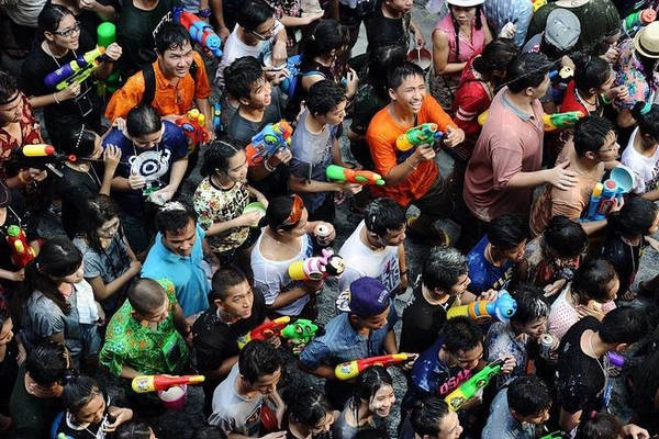Du khách nước ngoài vui đùa với một chú voi trong lễ hội té nước ở tỉnh Ayutthaya.