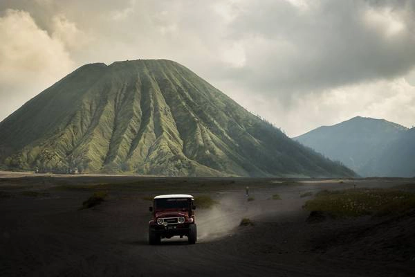 Chiếc ôtô chở khách đi trên nền tro bụi núi lửa, với phông nền là ngọn núi Bromo hùng vĩ có thể khiến bất cứ ai có tinh thần phiêu lưu muốn xách balô lên và đi. Chiếc ôtô chở khách đi trên nền tro bụi núi lửa, với phông nền là ngọn núi Bromo hùng vĩ có thể khiến bất cứ ai có tinh thần phiêu lưu muốn xách balô lên và đi.