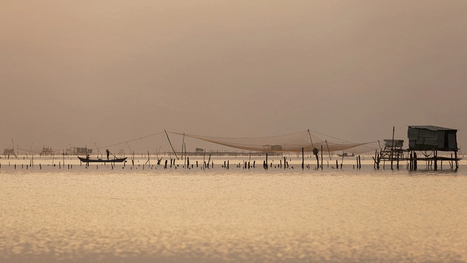 “Không chỉ đẹp khi nắng, vào những lúc trời mây mù, chuyển giông, mưa lớn, dãy núi phía sau đầm như có một bức màn khép lại và biến mất giữa khoảng không rộng lớn. Phóng tầm mắt ra xa, bạn có thể thấy những chòi canh nối tiếp nhau khi mờ khi tỏ tạo nên không gian ấn tượng” - nhiếp ảnh gia Nguyễn Phong (Huế), tác giả bộ ảnh chia sẻ.