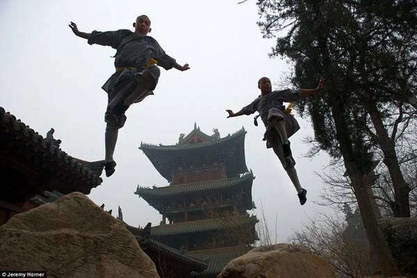 Các nhà sư của Thiếu Lâm tự tại Trịnh Châu, Trung Quốc đang luyện Kungfu với bối cảnh ngôi chùa thiêng tuyệt đẹp phía sau. 
