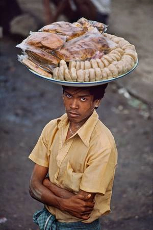 Người đàn ông đội mâm bánh trên đầu, bán rong trên đường phố Burma, Myanmar