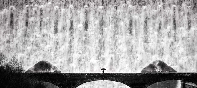 Bức ảnh gây ấn tượng mạnh này có tên là "Alone Against The Torrent", được nhiếp ảnh gia Paul Fowles chụp tại đập Caban Coch ở thung lũng Elan, Xứ Wales.  Fowles cho biết người phụ nữ trong bức ảnh là vợ của anh, người "tự nguyện" đứng trước thác nước tuôn chảy dữ dội.