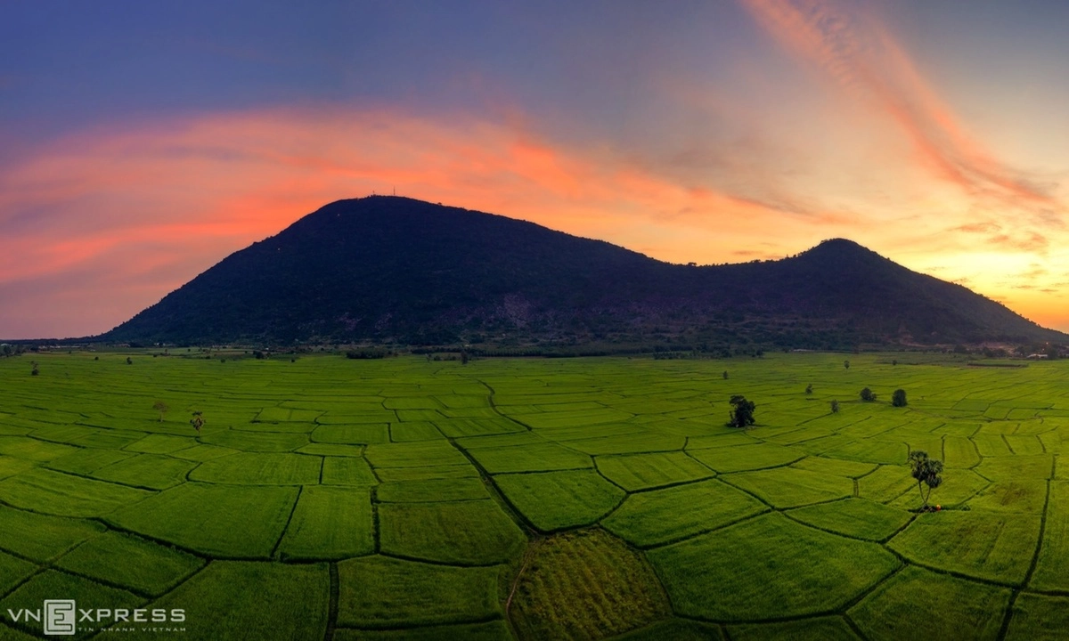 Toàn cảnh núi Bà Đen nhìn từ những ô ruộng xanh mướt, điểm xuyết bởi cây thốt nốt. “Đệ nhất thiên sơn” Núi Bà Đen cao 986 m, được xem là “nóc nhà” của vùng Nam bộ, là Di tích lịch sử và danh thắng cấp quốc gia. Bộ ảnh do nhiếp ảnh gia Nguyễn Tấn Tuấn, hiện sống và làm việc tại TP HCM, thực hiện trong các lần về thăm nhà.