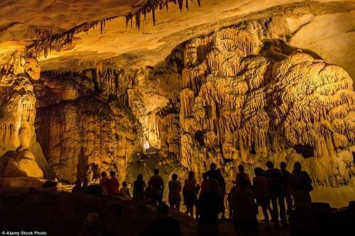 Du khách chiêm ngưỡng vẻ đẹp của nhũ đá trên thành của hang động. Du khách chiêm ngưỡng vẻ đẹp của nhũ đá trên thành của hang động.