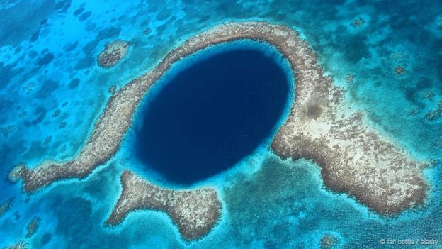 <strong>Hố xanh khổng lồ, Belize: </strong> Hố xanh khổng lồ có đặc điểm là chìm dưới nước, rộng 320 m và sâu 125 m. Nơi đây là một phần của rặng san hô Belize Barrier và Mesoamerican. Hố này được cho là hình thành từ thời kỷ nguyên băng hà khi một hệ thống hang động đá vôi ngập nước bị sụp đổ do sự thay đổi của mực nước biển. Thạch nhũ được tìm thấy trong hố có giá trị to lớn trong việc tìm hiểu về khí hậu của thời kỳ trước.