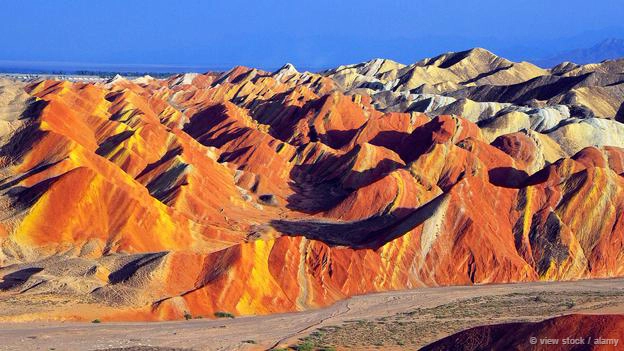 <strong>Công viên địa chất Zhangye Danxia, Trung Quốc: </strong> Những ngọn núi cầu vòng nhìn từ xa trông giống như một bức tranh. Dạng địa hình ở Danxia, tỉnh Cam Túc, Trung Quốc được hình thành từ những mảnh đá sa thạch đỏ và các trầm tích tích tụ qua hàng triệu năm. Nhờ hình thù độc đáo và kỳ lạ ở khu vực này khiến công viên địa chất Zhangye Danxia trở thành điểm tham quan du lịch hấp dẫn.