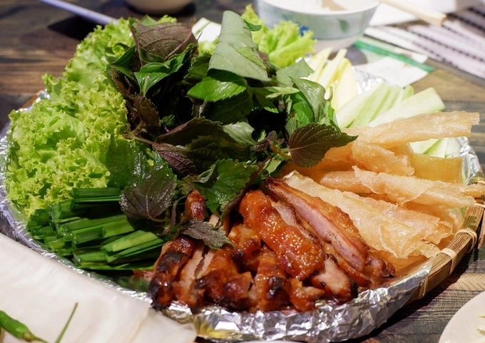 Hay nem nướng Nha Trang cuốn với rau sống, bánh tráng chiên giòn chấm nước sốt chuẩn vị, ngon lành.