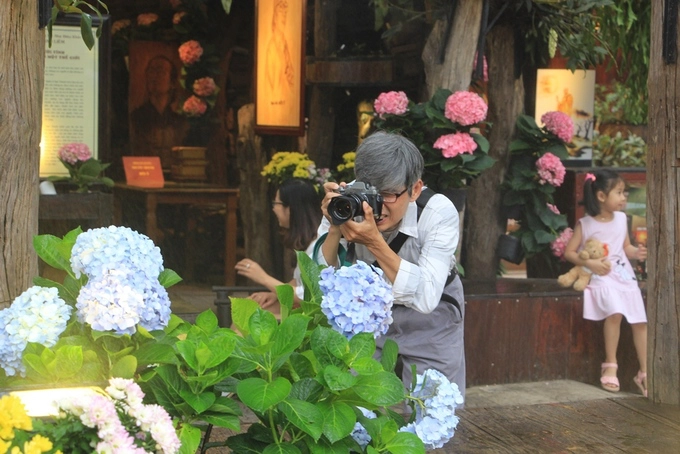 Một người dân say sưa chụp hoa. Một người dân say sưa chụp hoa.