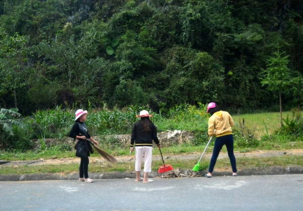 Người dân quét dọn đường xá đón khách du lịch - Ảnh: Phạm Tô Chiêm