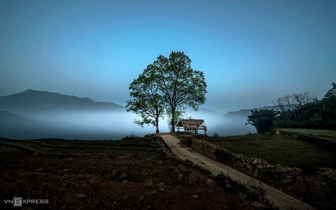 Mây trôi tại bản Choản Thèn lúc chiều tối. Trong ảnh là công viên mang tên Choản Thèn. Người dân địa phương thường gọi nơi này là “công viên Y Tý”, “công viên Choản Thèn” hoặc “hai cây song song”, nằm trên khoảng đất trống cuối con đường chạy dọc bản.